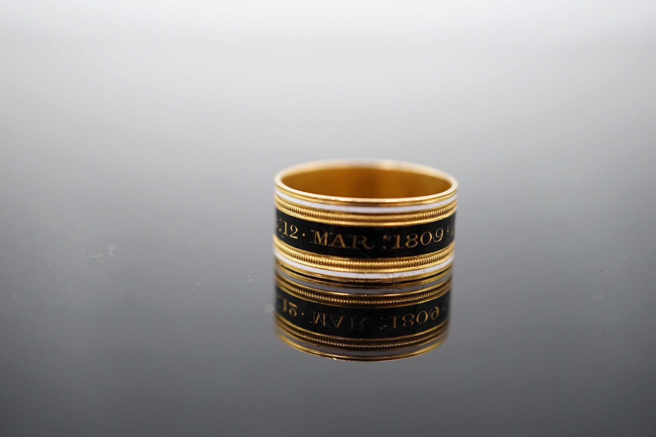 A George III 22ct gold and two colour enamel mourning band, inscribed 'Mary Powell OB. 12 Mar, 1809'